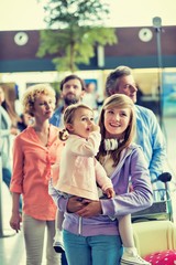 Obraz premium Family on holiday queueing for check in at airport 