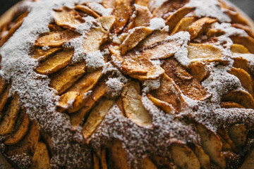 Closeup tasty natural food texture of apple pie with powdered sugar sprinkle baked at home