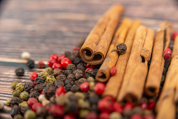 Cinnamon and spices in bulk lie on a dark wooden background.