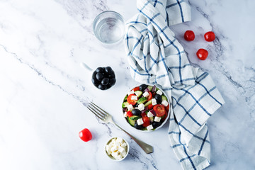 Greek Salad with ingredients in a white bowl