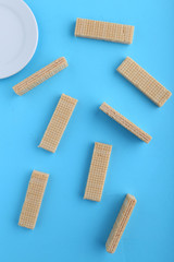Tasty wafer sticks on Blue background, flat lay. Sweet food