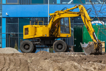 Fototapeta premium Excavator loader during earthworks at a construction site. The excavator is on the construction of a new park area. Excavator without a driver.