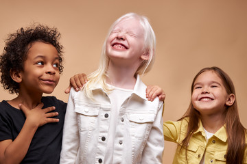 portrait of adorable diverse children isolated. black afro, albino and european children stand...