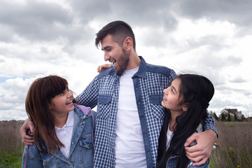 Happy father hugs two daughters, photo for Father's Day