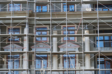 scaffolding at the facade of a building under construction, multi-storey building, without people