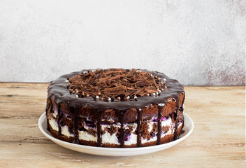 Homemade chocolate cake with whipped cream, blueberry jam and chocolate chips