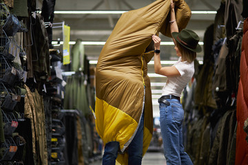 enthusiastic travellers looking for camping sleeping bag in store, they choose the best bag in...