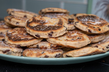 Stack of Homemade Welsh Cakes (Bakestones) freshly cooked on a green plate