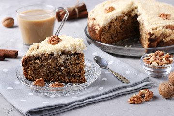Homemade crumb cake with walnuts and cinnamon in plate on gray concrete background, closeup, horizontal format