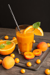 orange apricot physalis juice in a glass and decoration around on a wooden table
