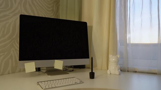 A desktop with a computer by the window.