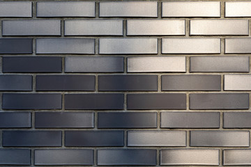 The texture of a brick wall with a ceramic facing brick is dark gray-brown. Image for construction and architectural design. Modern decoration of cottages and houses.