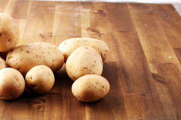 Fototapeta na wymiar Pile of potatoes lying on wooden boards. Fresh healthy potato