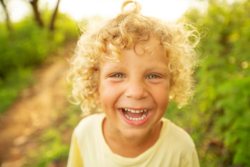 Portrait of a curly white boy in the park