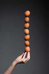 Stack of brown eggs on female hand