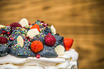 Pavlova dessert with fresh fruit and sweet cream.Closeup