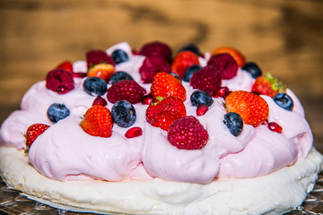 Pavlova dessert with fresh fruit and sweet cream.Closeup