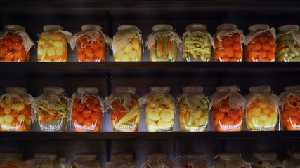 Jars of vegetables on the shelf. Stocks of vegetables in banks on a shelf. 