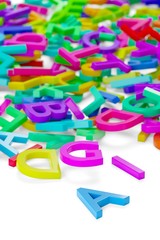 Heap of colorful rainbow alphabetic plastic character letters over white background, literature, education, know-how or writing concept