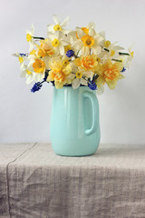 yellow and white daffodils in a blue enameled jug.