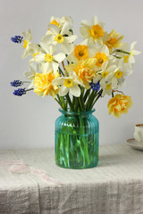 yellow and white daffodils in a blue glass vase.