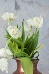 Obraz na płótnie Canvas White tulips in old copper vase
