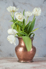 White tulips in old copper vase