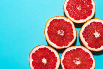 Five grapefruit on blue mint background. Summer wallpaper with space for text. Juicy tropical citrus fruit