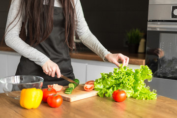 Young trendy woman cooking healthy food in the morning