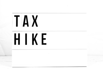 Modern Business Tax Hike Sign on Retro Board. Flat Lay