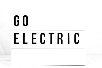 Go Electric Information Sign on isolated retro board. Climate Change