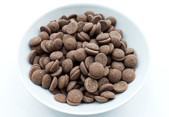 Small milk chocolate chips in a white bowl