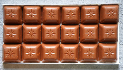 Milk chocolate bar with nuts close up. Fast carbohydrates.