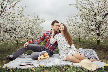 Young couple relaxing in the garden. Girl with a guy in the garden. In love on a walk in nature.