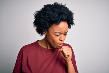 Fototapeta na wymiar Young beautiful African American afro woman with curly hair wearing casual t-shirt standing feeling unwell and coughing as symptom for cold or bronchitis. Health care concept.