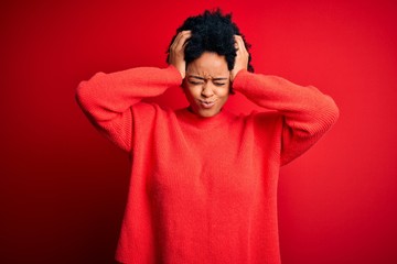 Fototapeta na wymiar Young beautiful African American afro woman with curly hair wearing casual sweater suffering from headache desperate and stressed because pain and migraine. Hands on head.