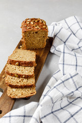 Homemade crusty loave of bread with pumpkin seeds on light grey background