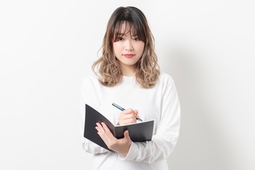 Fototapeta premium ノートにメモをとる女性