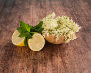 Preaparation for home made Elderberry syrup. Home made with sugar, and lemons. On the wooden background.