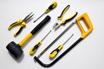 Set of black and yellow working tools, pliers, wire cutters,
screwdrivers, hammer and saw which can...