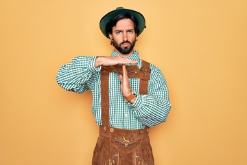 Young handsome man wearing tratidional german octoberfest custome for Germany festival Doing time...