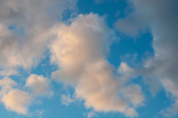 Dramatic cloudscape sky with dark storm clouds, blue sky and orange pink tinted clouds.  Great for backgrounds, weather, science, meteorology concepts.