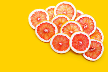 High vitamin C. Juicy grapefruit slices on yellow background.