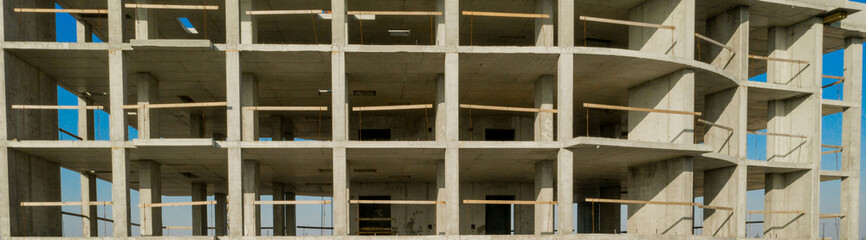 Fototapeta na wymiar Aerial view of concrete frame of tall apartment building under construction in a city