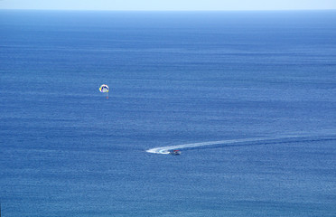 Naklejka na ściany i meble Skydiving tourists on the sea for a motor boat on vacation