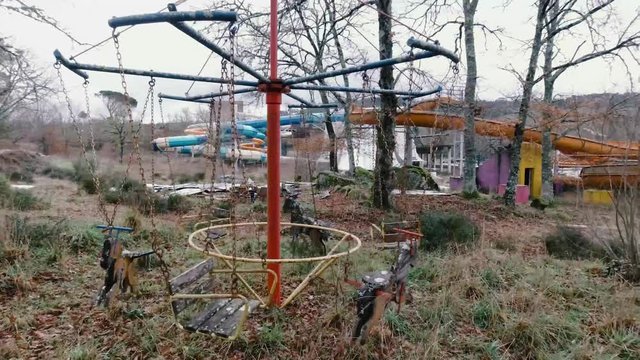 columpio infantil abandonado en parque acu&aacute;tico. Columpio movi&eacute;ndose solo