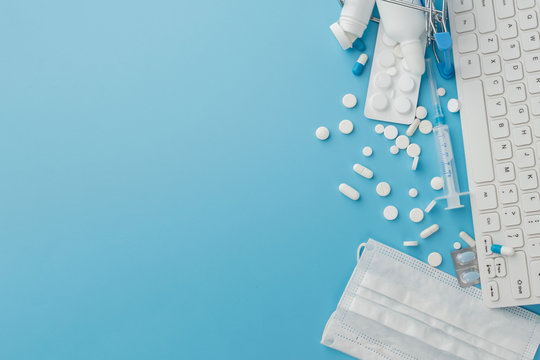 Shopping Cart Toy With Medicaments And Keyboard. Pills, Blister Packs, Medical Bottles, Thermometer, Protective Mask On A Blue Background. . 