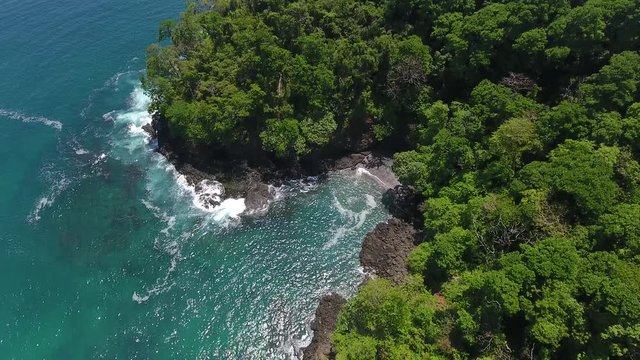 Backward Flying Camera Roll Reveal Aerial View of Cavada Island (Isla Secas) Water Edge with Clear Torquise Colored Water, White Sand Beach Coves and Rock Cliff Shore