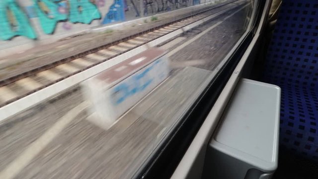 The view Through dirty Window of a moving commuter train in Hamburg  on the fields sweeping outside the window