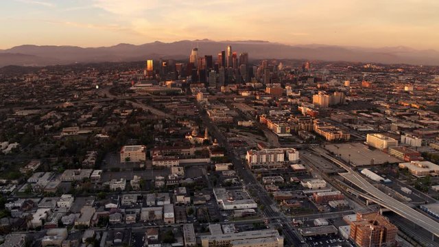 Downtown Los Angeles in golden light of sunset aerial view, business centre of the city, mountains in a background of skyscrapers